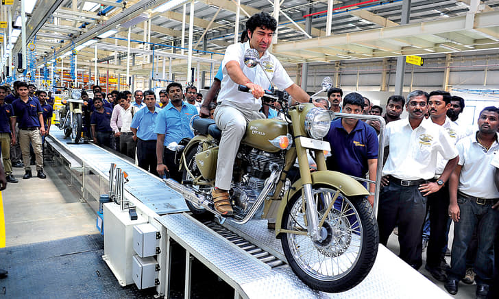 Siddhartha Lal rolls the first production motorcycle off the assembly line. 